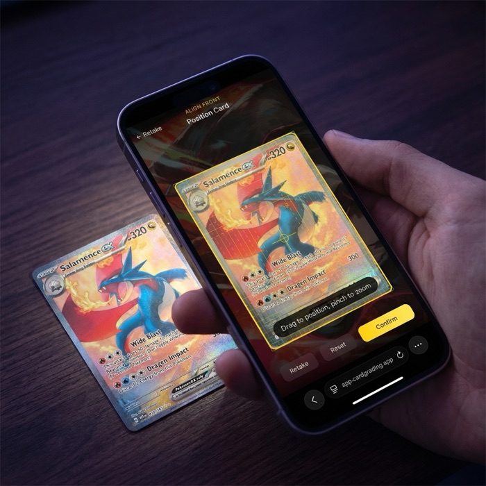 Hand holding a phone scanning a Pokemon card with the CardGrading.app AI grading interface showing centering overlay and alignment guides